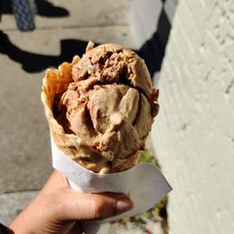 a hand holding a cone of ice cream
