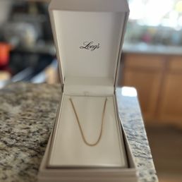 Elegant presentation of a gold chain in a Long's box
