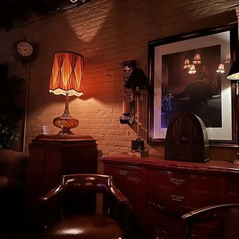Mata Hari's - a room with a mirror and a lamp - Lounges Near Me - Savannah, Georgia