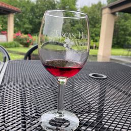 a glass of wine on a table a glass of wine on a table