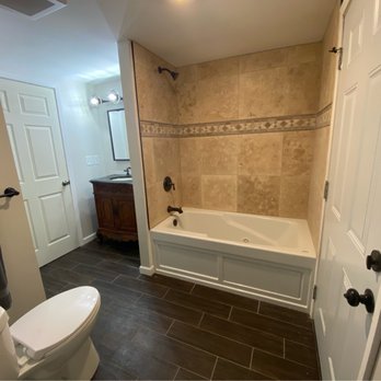 Upside-Down Remodeling - Finished bathroom floor and tile in bathtub - Tiling Near Me Upside-Down Remodeling - Finished bathroom floor and tile in bathtub - Tiling Near Me