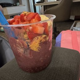 Acai bowl with peanut butter, granola, bananas, and strawberries.