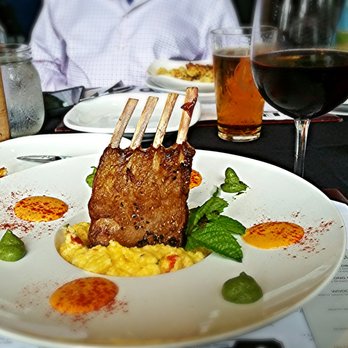 Foxhole Culinary Tavern - New Zealand Lamb Rack with a glass of Sea Glass Pinot Noir. - New American Near Me - Austin, Texas Foxhole Culinary Tavern - New Zealand Lamb Rack with a glass of Sea Glass Pinot Noir. - New American Near Me - Austin, Texas