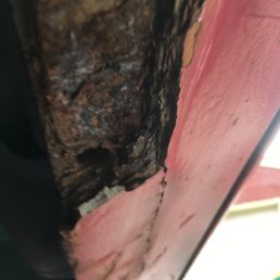 Missing chunks of body filler improperly applied to a heavily rusted rocker panel and then just painted over.