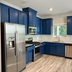 Palacios Construction Group - Kitchen painting in Conroe TX - Bold blue cabinets with modern hardware, granite countertops and herringbone backsplash.