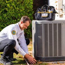 Youngberg's One Hour Heating & Air Conditioning - Tech cleaning around AC.