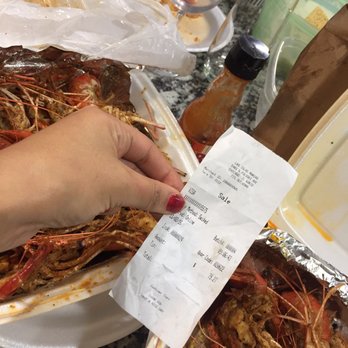 Las Islas Marias - a woman's hand holding a receipt in front of a plate of shrimp - Seafood Near Me - Chicago, Illinois