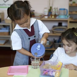 Casa dei Bambini School - Students prepare and serve each other snack as part of a lesson.