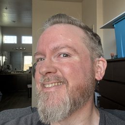After photo of men's short gray haircut and full beard trim by Dominick at Mission Barbers (Gilbert, AZ) showing clean lines and sharp edges