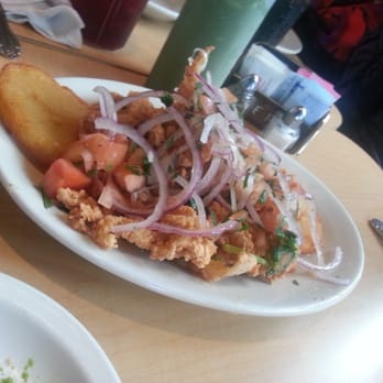 Inkas - Fried Calamari Fresh calamari dipped in famous secret batter, fried and topped w/ sarza criolla. (marinated onions with lime juice) - Peruvian Near Me - Irvine, California