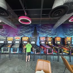 Kid playing pinball at brewery