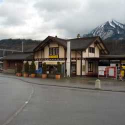 Mc One - Aussenansicht mit Sonnenterrasse. Der Bahnhof "Alpnach Dorf" ist mit dem Vordach integriert ins Gebäude.