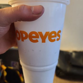 Popeyes Louisiana Kitchen - a hand holding a cup of coffee - Chicken Wings Near Me - Florence, Kentucky