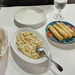 Hummus, pita bread,, baba ghanoush, rolled spinach pies, fatoush salad