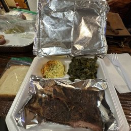 Ribs, collard greens, potato salad, slice of bread.