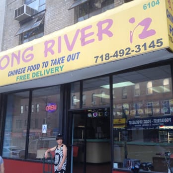 Long River - a woman standing in front of a restaurant - Chinese Near Me - Brooklyn, New York