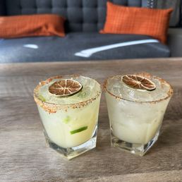 two margaritas with orange slices on the rim