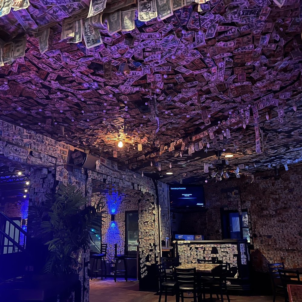 a restaurant with money hanging from the ceiling