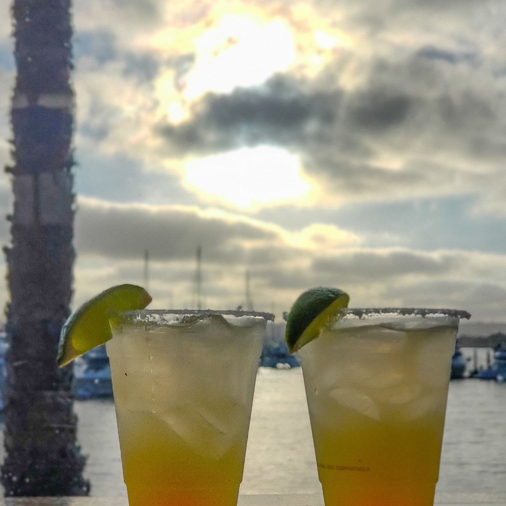 two cocktails on a table with a view of the ocean two cocktails on a table with a view of the ocean