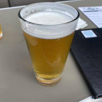 Tullys Taproom - Oberon Ale Beer - A tall glass filled with Oberon Ale beer, with a foamy head, placed on a table at Tullys Taproom in O'Fallon, MO. - American Near Me - O'Fallon, Missouri