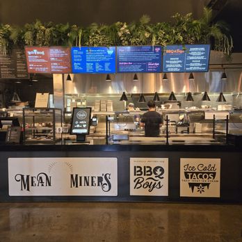 Revolve Hall - Ordering counter - A food counter with digital menu displays overhead and signage on the front, featuring brands like Mean Miners, BBQ Boys, and Ice Cold Tacos. - Tacos Near Me - Apple Valley, Minnesota