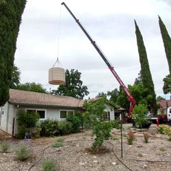 MIKE'S CRANE SERVICE - Hoisting a 400 lb water tank over a home in Chico.