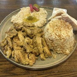 Chicken shawarma with rice, baba ghanoush, pita bread, and garlic sauce
