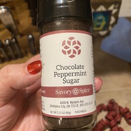 a hand holding a jar of chocolate peppermint sugar a hand holding a jar of chocolate peppermint sugar
