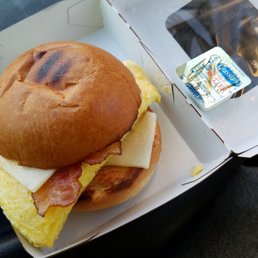 A super small breakfast sandwich note the butter packet as a size reference.. Total ripoff