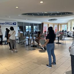 A line of customers waiting for the post office to open DURING THEIR BUSINESS HOURS, because it's closed.