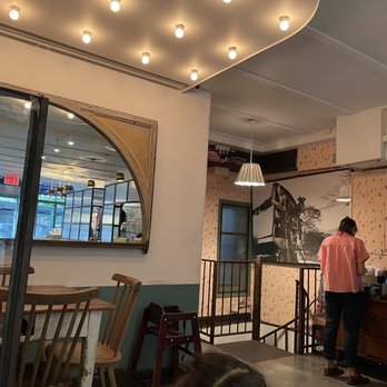 Epistrophy - a woman standing at a counter in a restaurant - Wine Bars Near Me - New York, New York