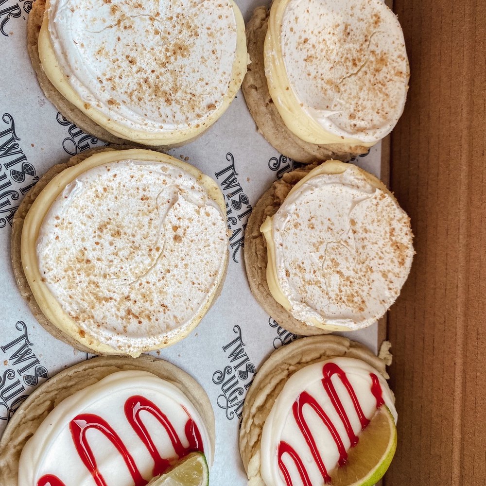 a box of cookies with icing and a slice of lime