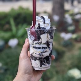 a hand holding a cup of ice cream a hand holding a cup of ice cream