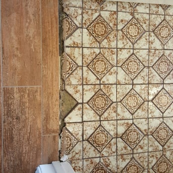 Sir G All Construction - Guest bath before- transition of tile from hallway to bathroom was ugly and uneven. - General Contractors Near Me