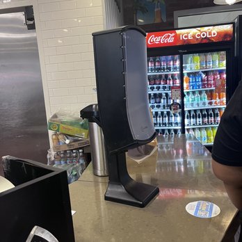 Twisted Root - a man sitting at a counter in a restaurant - Burgers Near Me - Dallas, Texas
