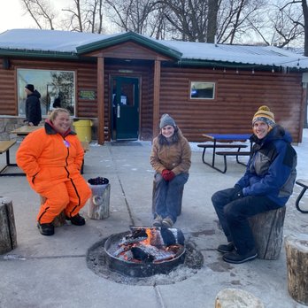 Events & Adventures - Friends sitting around the bonfire at the snow tubing hill. - Social Clubs Near Me - Golden Valley, Minnesota