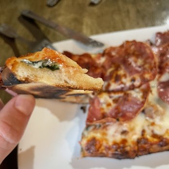 Pie - a hand holding a slice of pizza - Pizza Near Me - Bethany Beach, Delaware