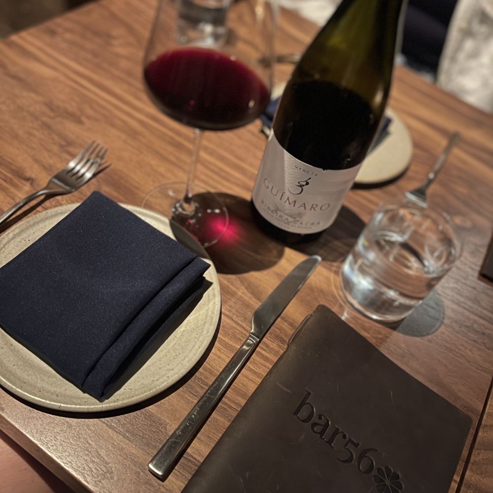 Bar 56 - a table setting with a wine bottle, napkin, and wine glass - New American Near Me - Brooklyn, New York
