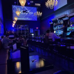 people sitting at a bar with chandeliers people sitting at a bar with chandeliers