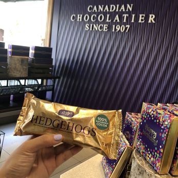Purdys Chocolatier - a person holding a chocolate bar - Desserts Near Me - Vancouver, British Columbia