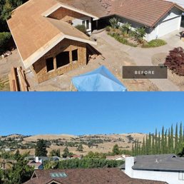 The image shows a residential house before and after a roof replacement. The 'before' photo depicts an unfinished roof with exposed plywood and partial roofing materials. The 'after' photo displays the completed roof with new brown shingles installed, covering the entire roof surface. The house is situated in a suburban neighborhood with other homes, trees, and distant hills visible in the background.