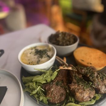 Zaya - Garlic Butter Lamb Chops, smoked greens, grits, and the magical disc of cornbread (that's what they should call it ) Soooo delicious! - Lounges Near Me - Los Angeles, California