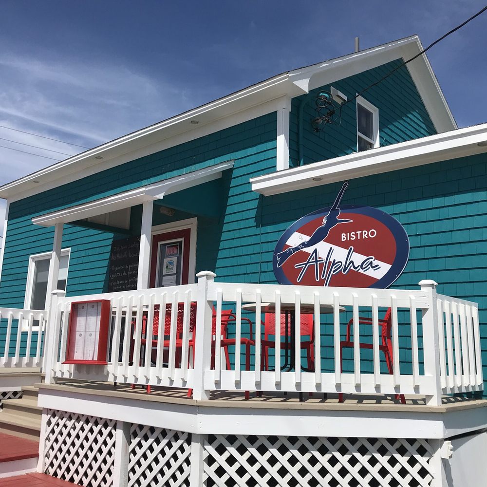 Bistro Plongée Alpha - a blue house with a sign that says bistro plong - Coffee & Tea Near Me - Grande-Entrée, Quebec