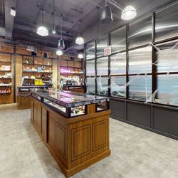 Grasshopper Club - Logan Square - Wide retail area with display cases and festive cobweb decor.