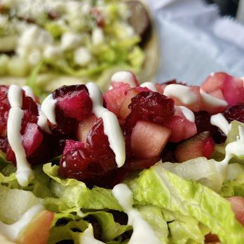 White Duck Taco Shop - a close up of a taco with lettuce and cranberry toppings - New American Near Me - Johnson City, Tennessee White Duck Taco Shop - a close up of a taco with lettuce and cranberry toppings - New American Near Me - Johnson City, Tennessee