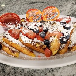 Biscuit House- Tumwater - Three slices of french toast with strawberries, blueberries, powdered sugar, syrup, and strawberry compote.