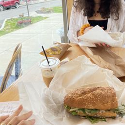 a woman sitting at a table with a sandwich