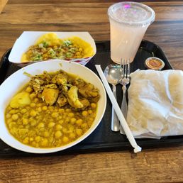 Boneless chicken curry with roti, Doubles and Trini Lemonade with a side of imported hot sauce. Perfect balance of sweet savory and spicy.