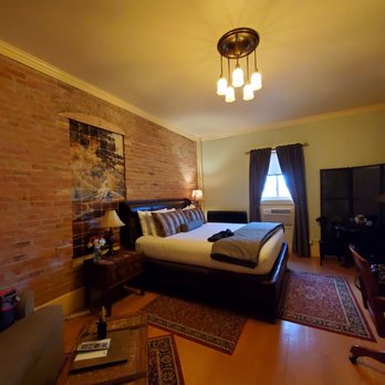 Chamberlin Inn - Nice bed with brick walls and a window that actually opens to the beautiful courtyard. - Hotels Near Me - Cody, Wyoming