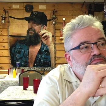Velma's Diner - My husband and the award winning quilt that hangs on the wall. My guess the man is someone important to them. Lots of Americana decor too. - Diners Near Me - Shoals, Indiana